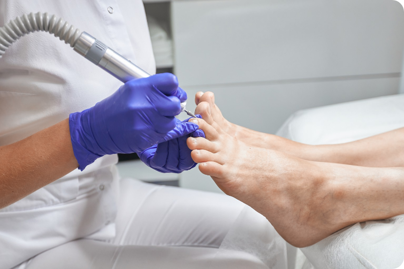 Profesional realizando cuidado podológico preventivo en los pies de un paciente